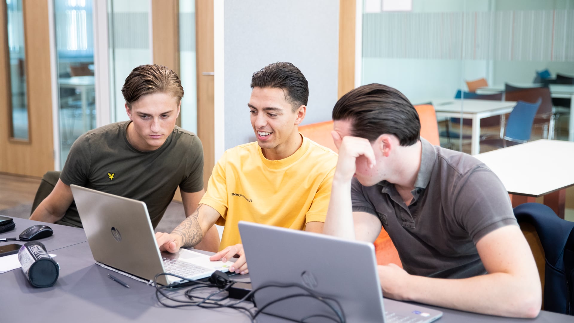 3 jongens kijkend naar een laptopscherm