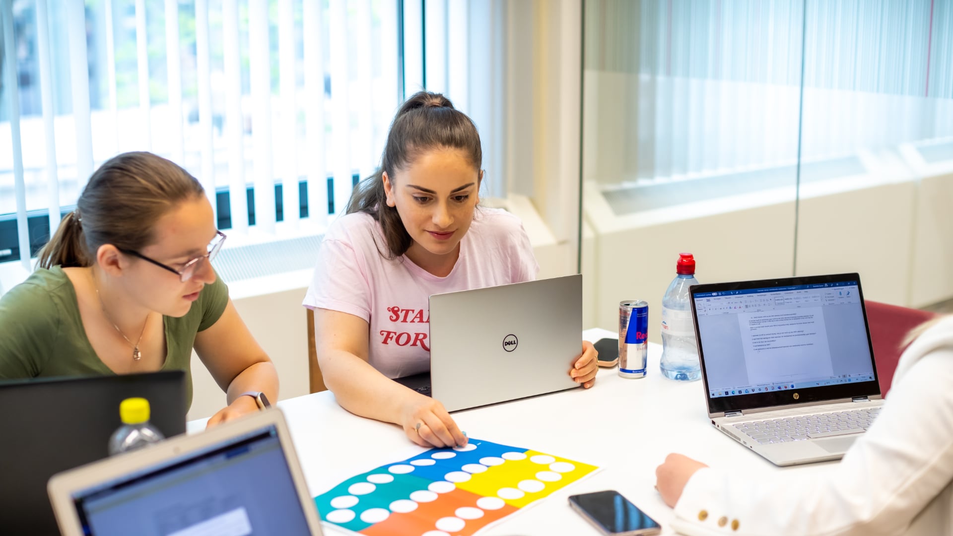 3 HRM studenten zitten aan tafel en bekijken een opdracht